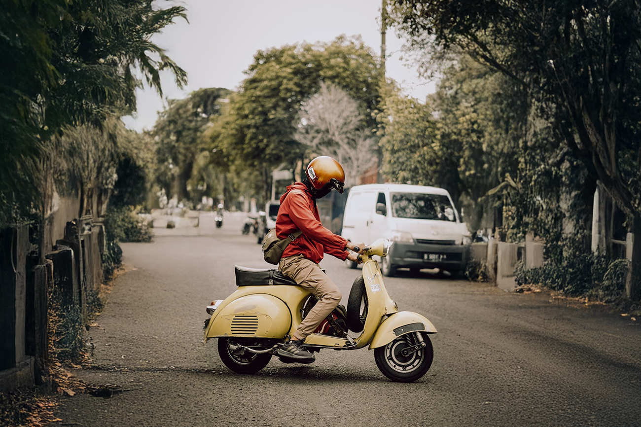 man wearing helmet riding scooter